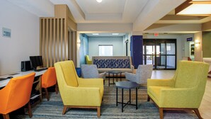 A modern lobby with yellow armchairs, a sofa, and a computer desk. - Holiday Inn Express Hotel & Suites Ocoee East by IHG (Orlando)