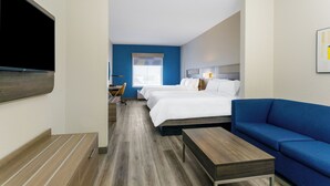 A hotel room with two beds, a blue sofa, a TV mounted on the wall, and a desk with a chair. - Holiday Inn Express Hotel & Suites Ocoee East by IHG (Orlando)
