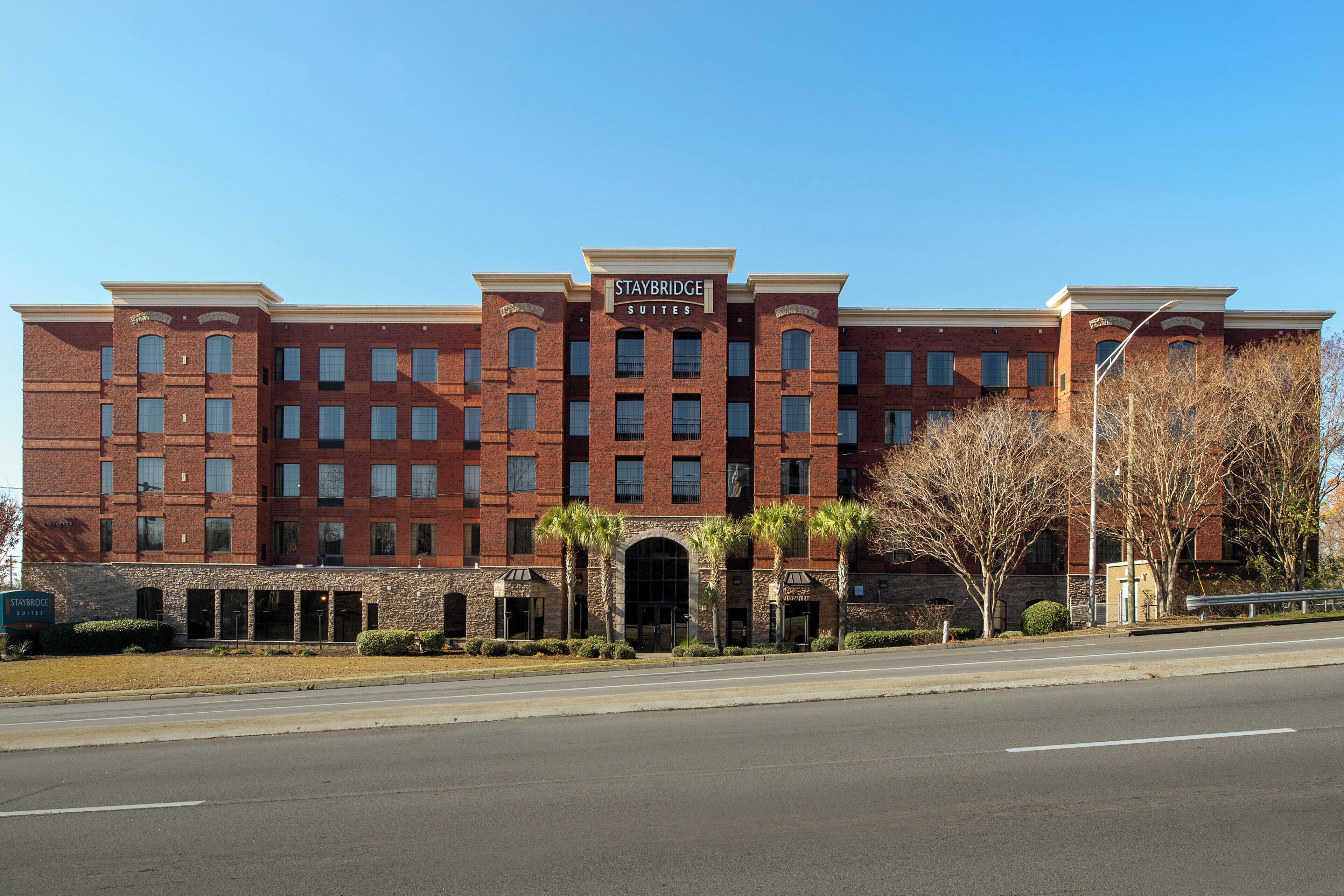 A multi-story brick building with a sign reading 'Staybridge Suites.'