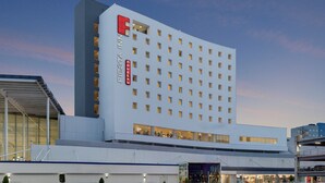 Ein modernes Hotel mit einem auffälligen 'F'-Logo, mehreren Etagen und einem flachen Dach.