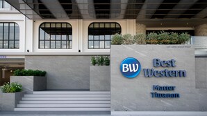 Una entrada moderna de edificio con un letrero que dice "Best Western Matter Tiwanon".