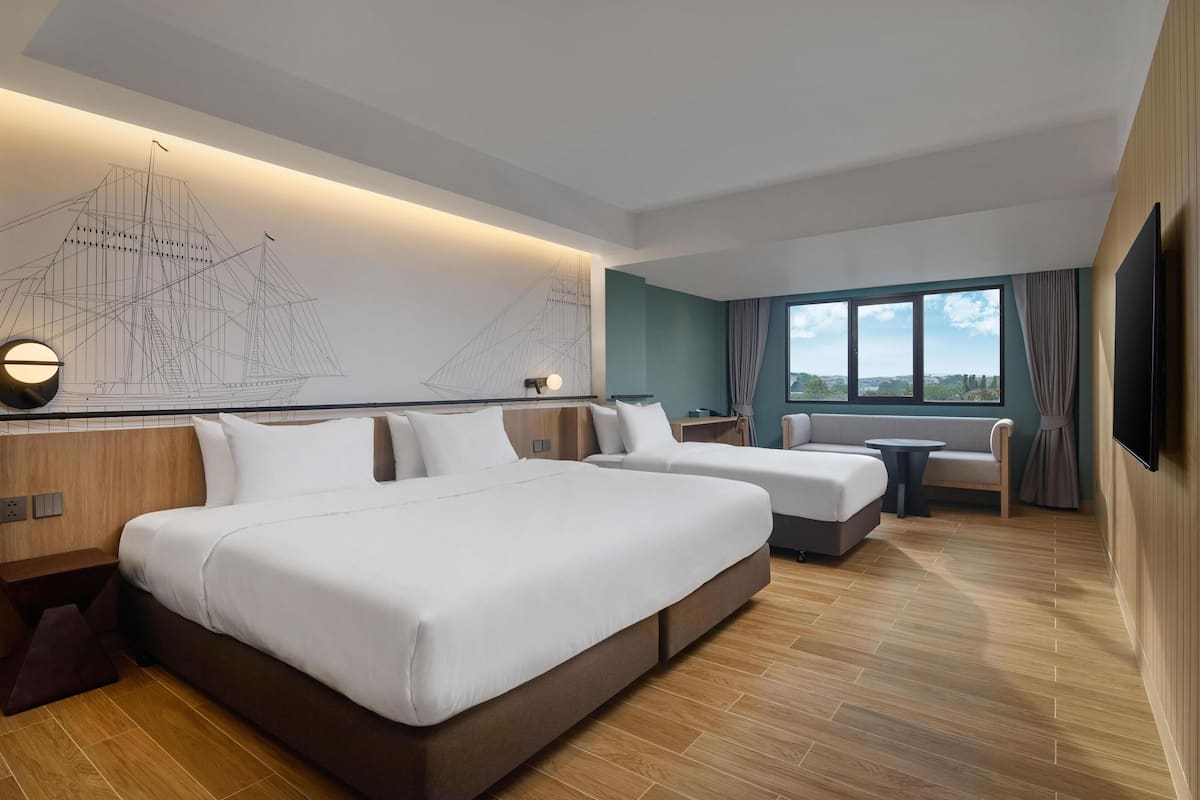 Een moderne hotelkamer met een groot bed, een bank, een tafeltje en een televisie.