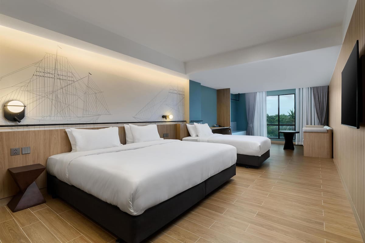 Een moderne hotelkamer met twee bedden, een groot raam met gordijnen, een schilderij van een schip aan de muur en een flatscreen televisie.