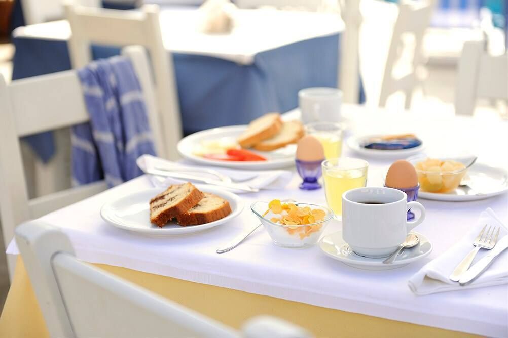 A breakfast table with plates of toast, eggs, and a cup of coffee.