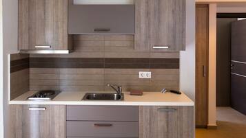 A modern kitchen with wooden cabinets, a stainless steel sink, and a built-in stove.