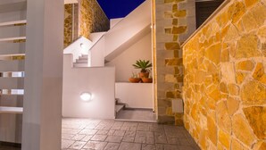 Un intérieur moderne avec un escalier, des murs en pierre et une plante en pot.