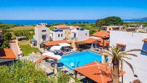Un complexe hôtelier doté d’une piscine, de plusieurs bâtiments et offrant une vue sur la mer.