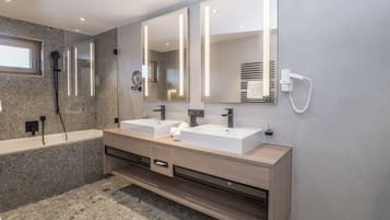 Un baño moderno con dos lavamanos, un espejo grande y una ducha integrada.