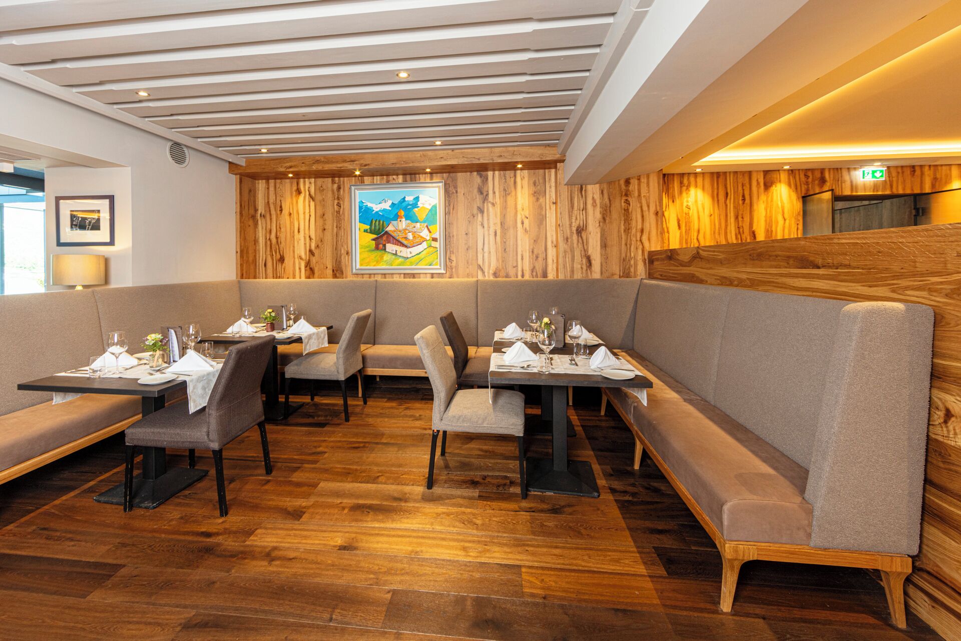 Un restaurante con paredes de paneles de madera, asientos tapizados y piso de madera.