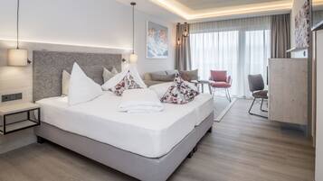 Una habitación de hotel moderna con una cama grande, mesitas de noche, un escritorio y una silla.