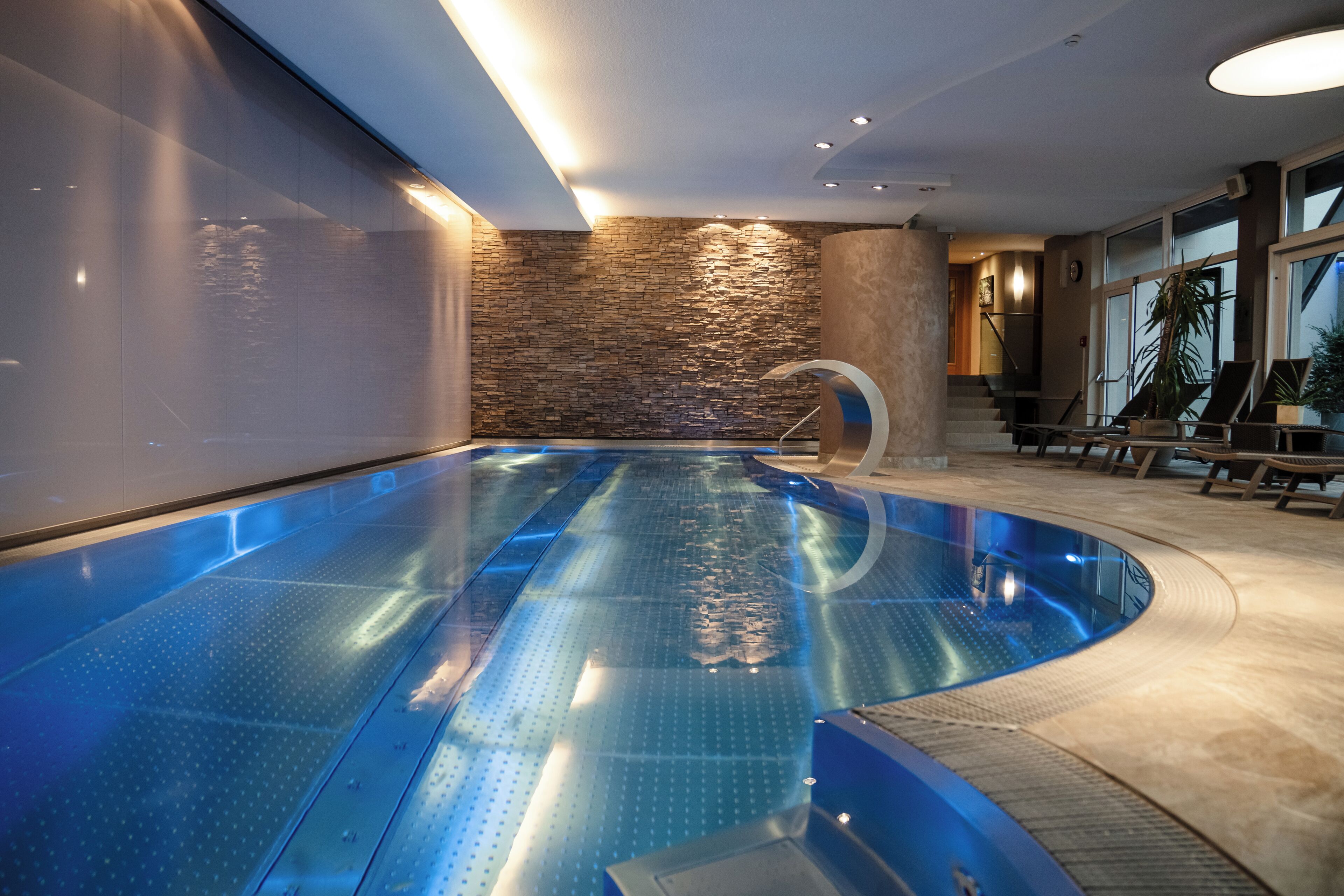 Una piscina techada, sillones reclinables de piscina