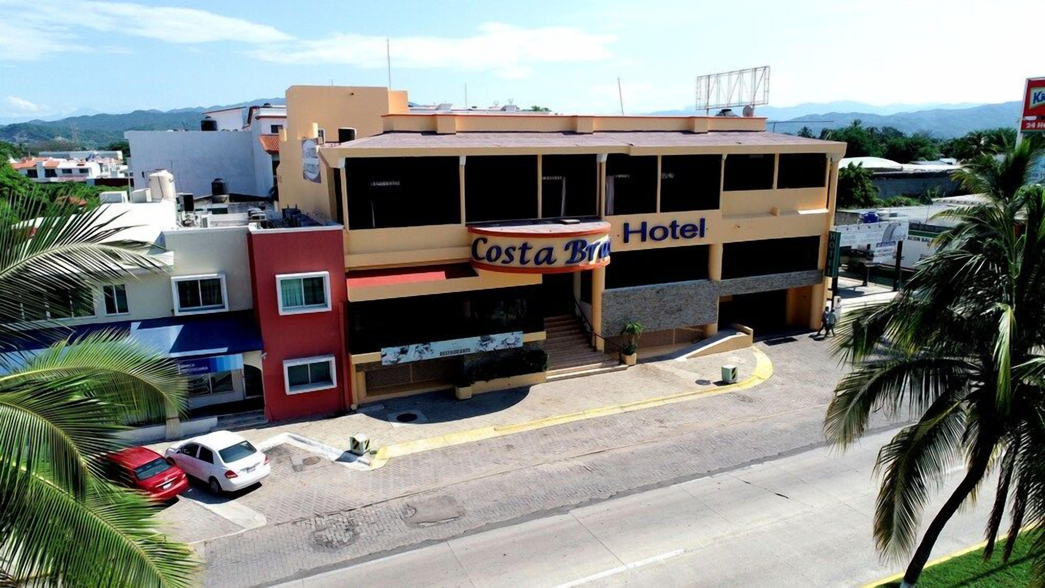 Un edificio de dos pisos con un letrero que dice 'Costa Brava Hotel'.