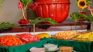 A buffet table with various food items and a large red pot in the background. - Costa Brava (Manzanillo)