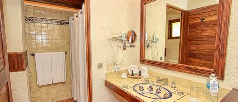 Un baño con ducha, inodoro, lavabo y un espejo grande.