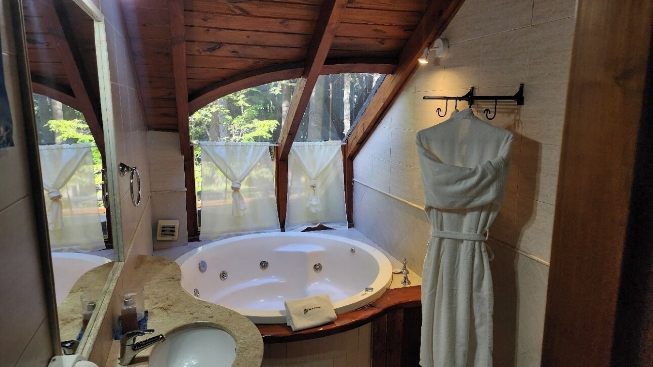 Un baño con una bañera grande, un lavabo y un espejo.