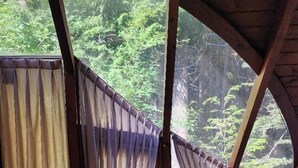 A room with a bed, a window with curtains, and a view of a forest. - Casa del Bosque Apart, Suites & Spa (Villa La Angostura)