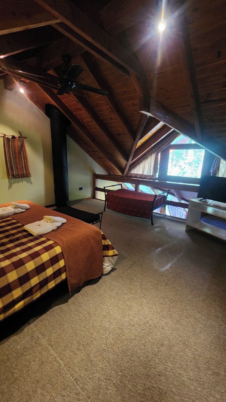 Una habitación con cama de altillo, escritorio y televisor.