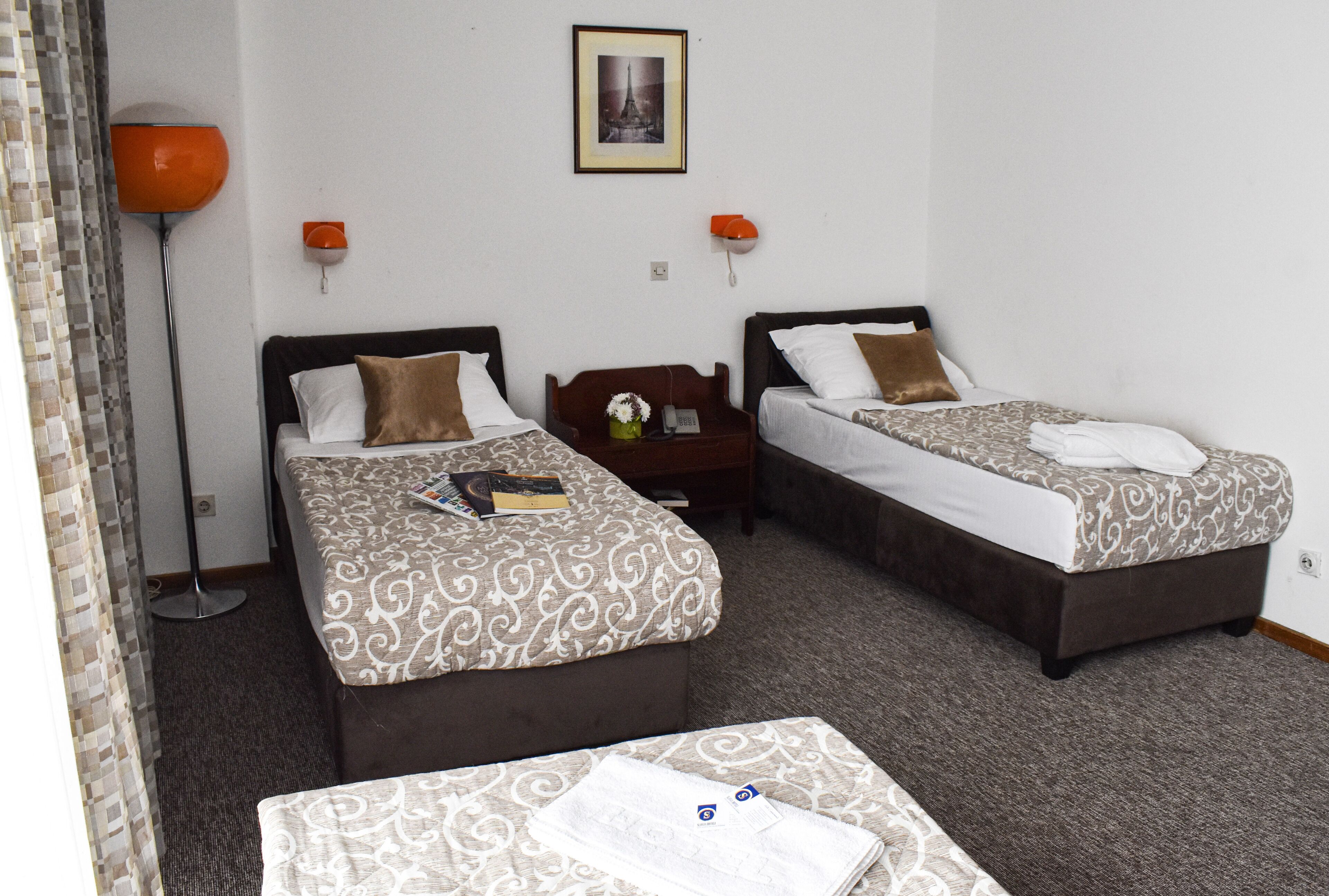Una habitación de hotel con dos camas, una mesita y una mesita de noche.