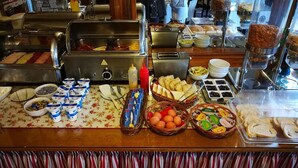 A buffet setup with various food items and condiments. - Hotel Lav (Belgrade)