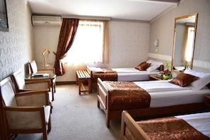 A hotel room with two single beds, a desk with a chair, a small table, and a bench. - Hotel Lav (Belgrade)