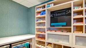 A snack and beverage display area with various packaged snacks and drinks. - Hampton Inn by Hilton Sudbury (Sudbury)