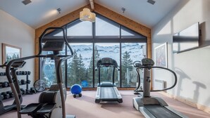 A gym with treadmills, ellipticals, and weights, large windows with a mountain view. - Pierre & Vacances Premium Flaine Les Terrasses d'Eos (Araches-la-Frasse)