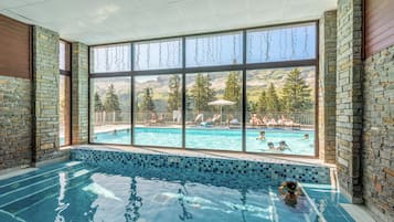 Una piscina al aire libre de temporada, sombrillas