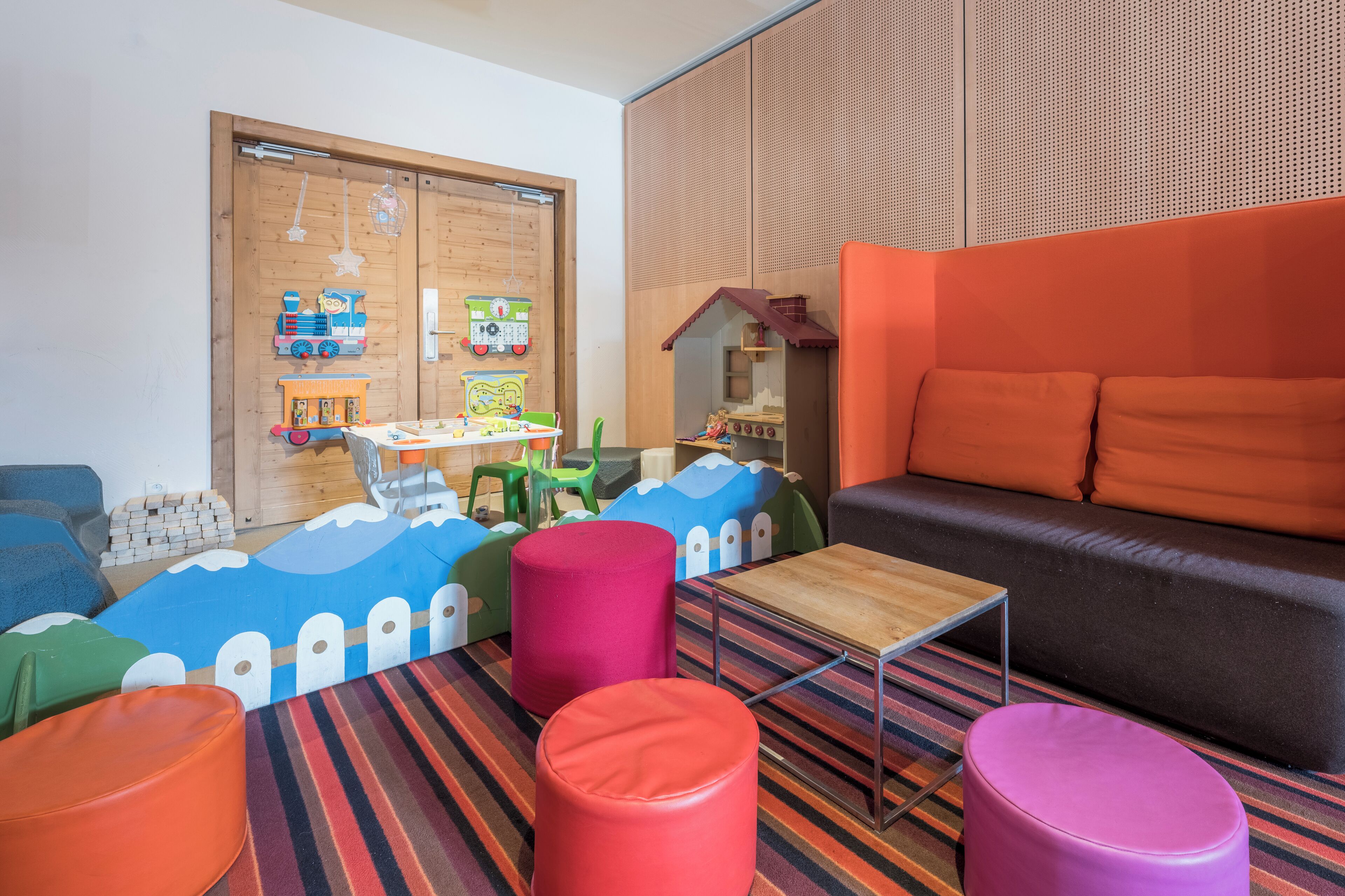 A children's play area with colorful furniture and a wooden play kitchen.