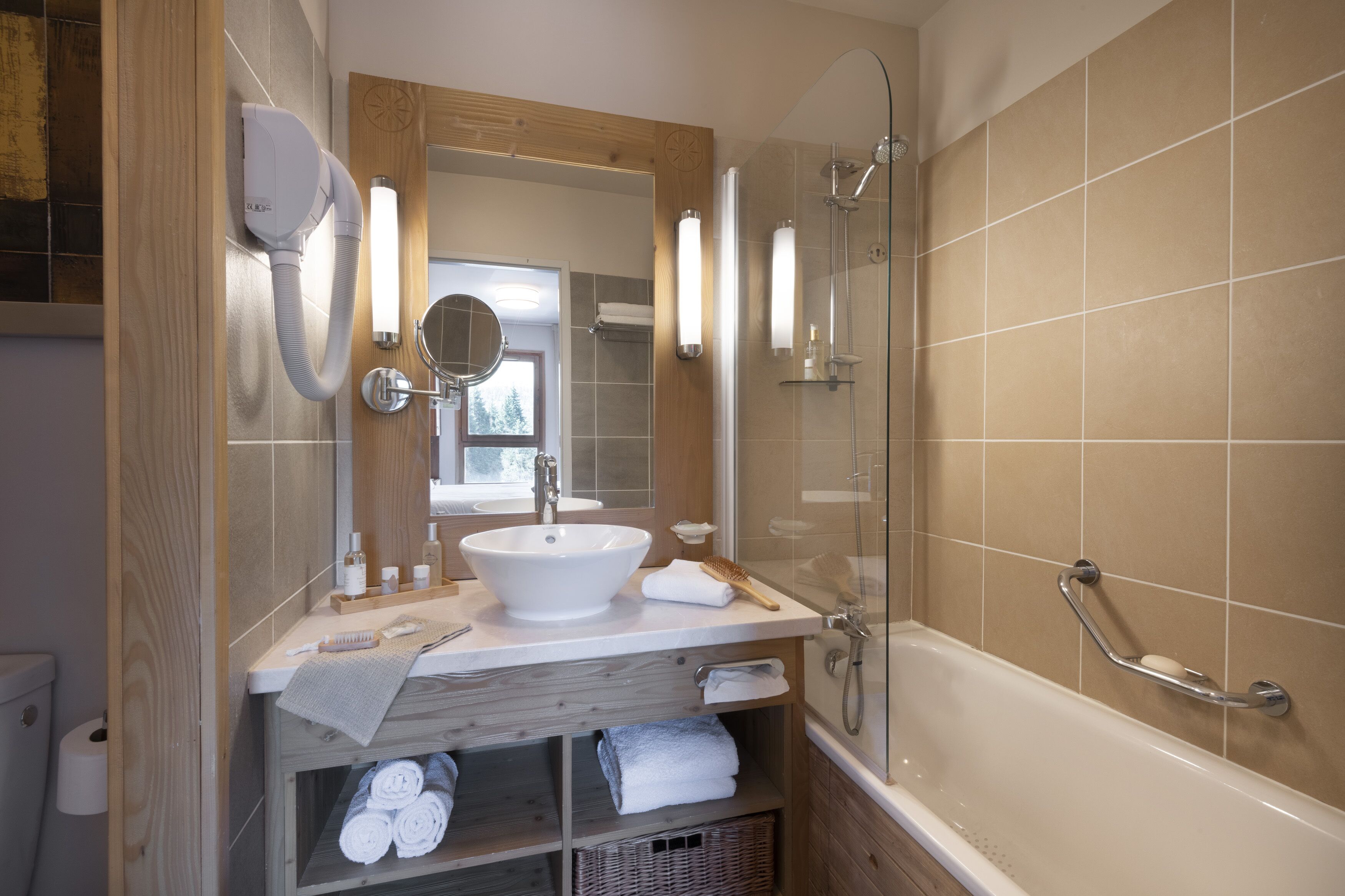 A modern bathroom with a sink, mirror, and shower.