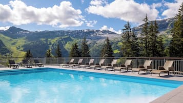 Una piscina al aire libre de temporada, sombrillas