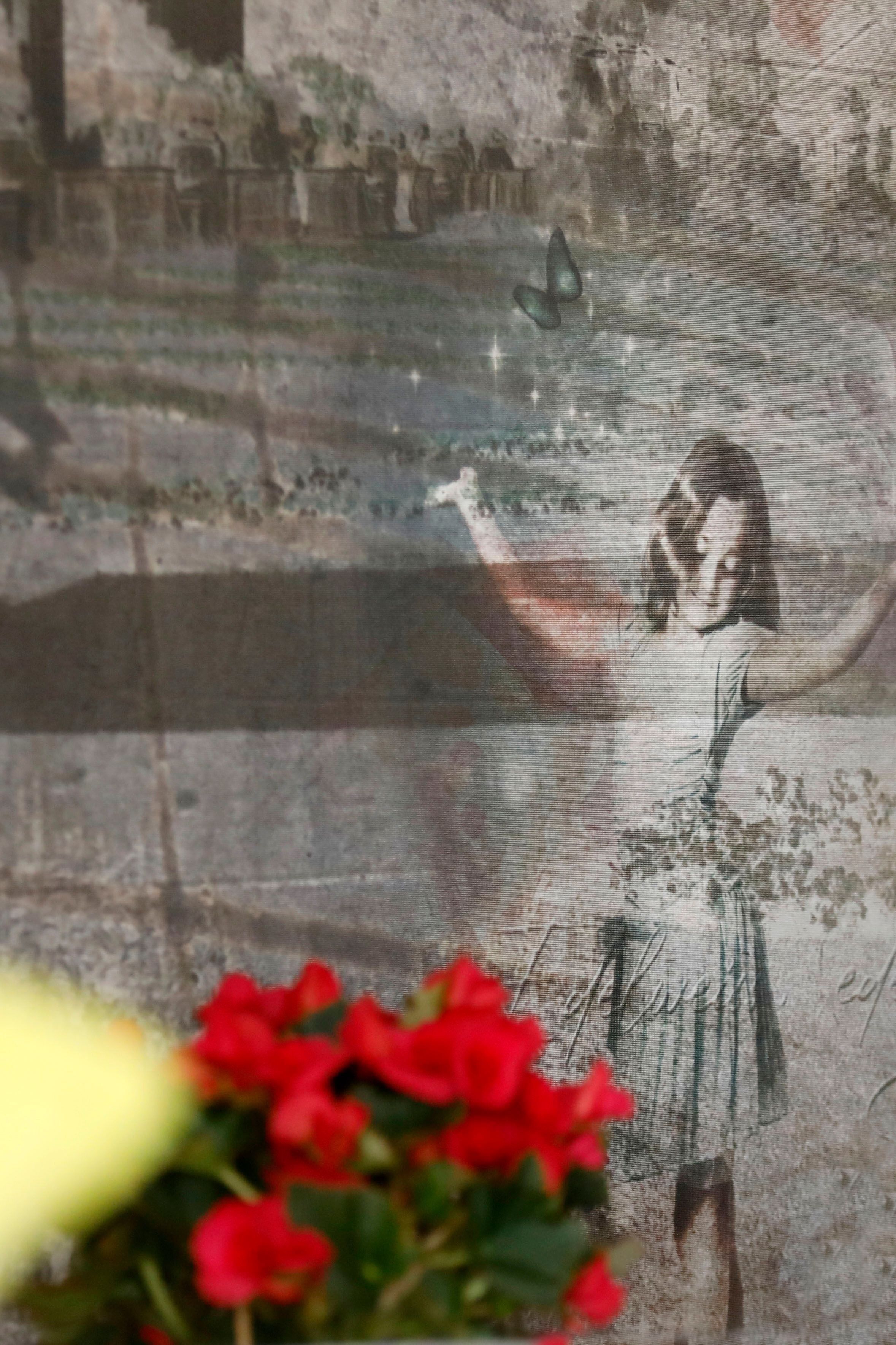 Un mural de estilo antiguo con una figura con vestido y brazos extendidos.