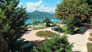 Un parque con mesas de picnic, bancos y un asta de banderola.