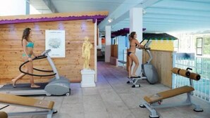 Un gimnasio con equipo de ejercicio, una pared de madera y una estatua.