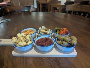 A wooden table with six bowls of food.