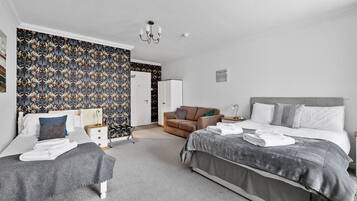 A bedroom with a bed, a chair, a bedside table, and a wardrobe.