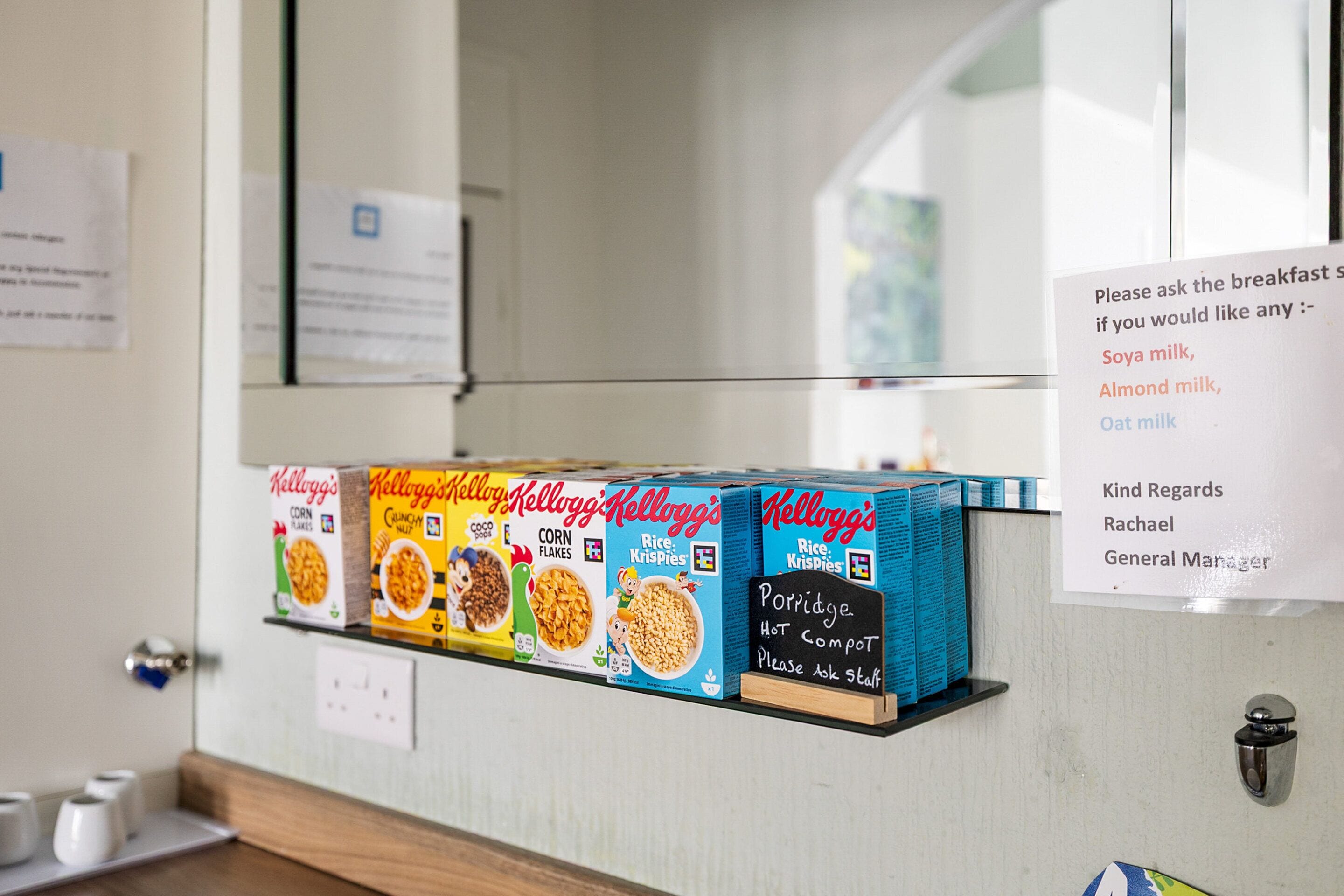 A breakfast bar with Kellogg's cereal boxes and a sign offering breakfast options.