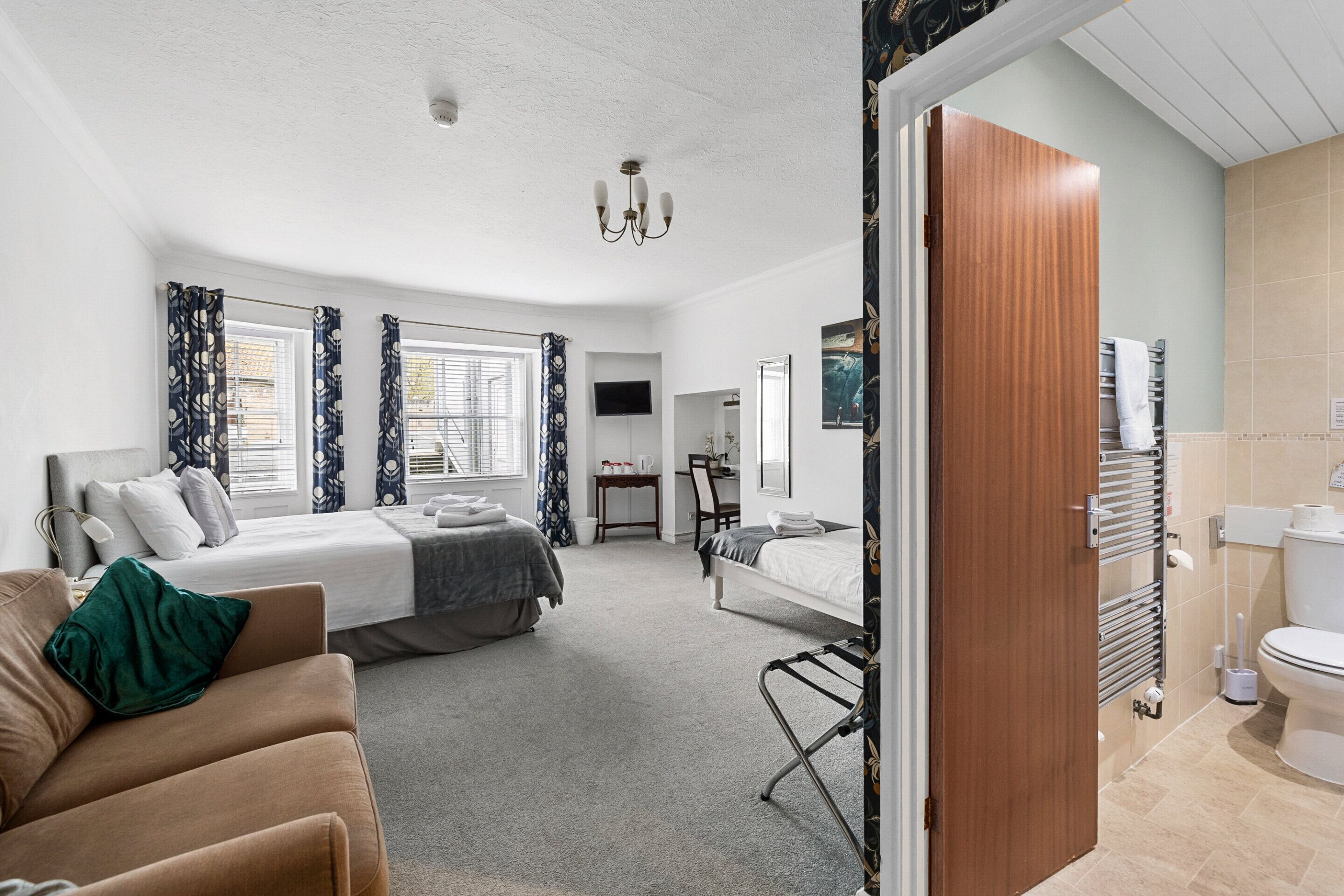 Una habitación de hotel moderna con cama, sofá, escritorio y baño.