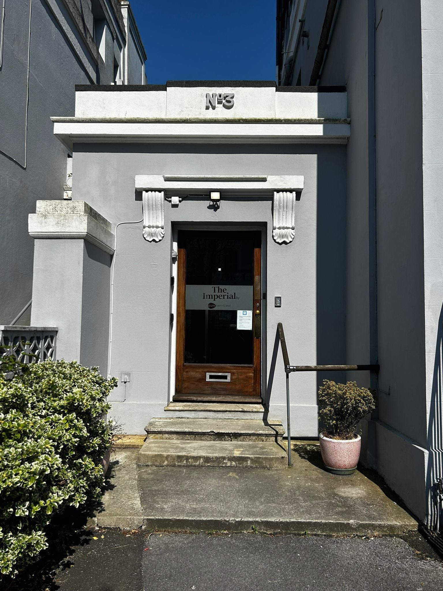 A building entrance with a sign reading "The Imperial By" and a number "N°3" above the door.