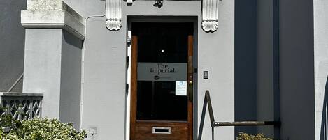 A building entrance with a sign reading "The Imperial By" and a number "N°3" above the door.