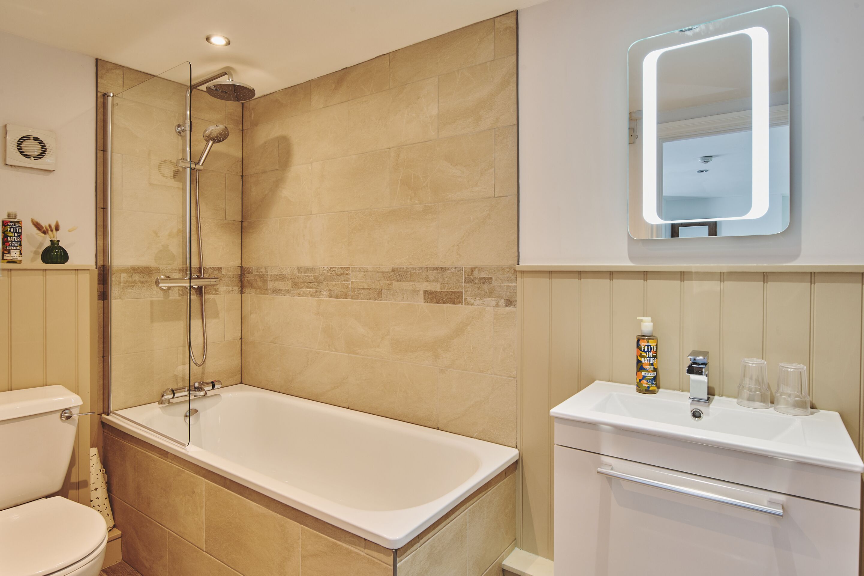 Ein Badezimmer mit Badewanne, Dusche, Toilette, Waschbecken und Spiegel.