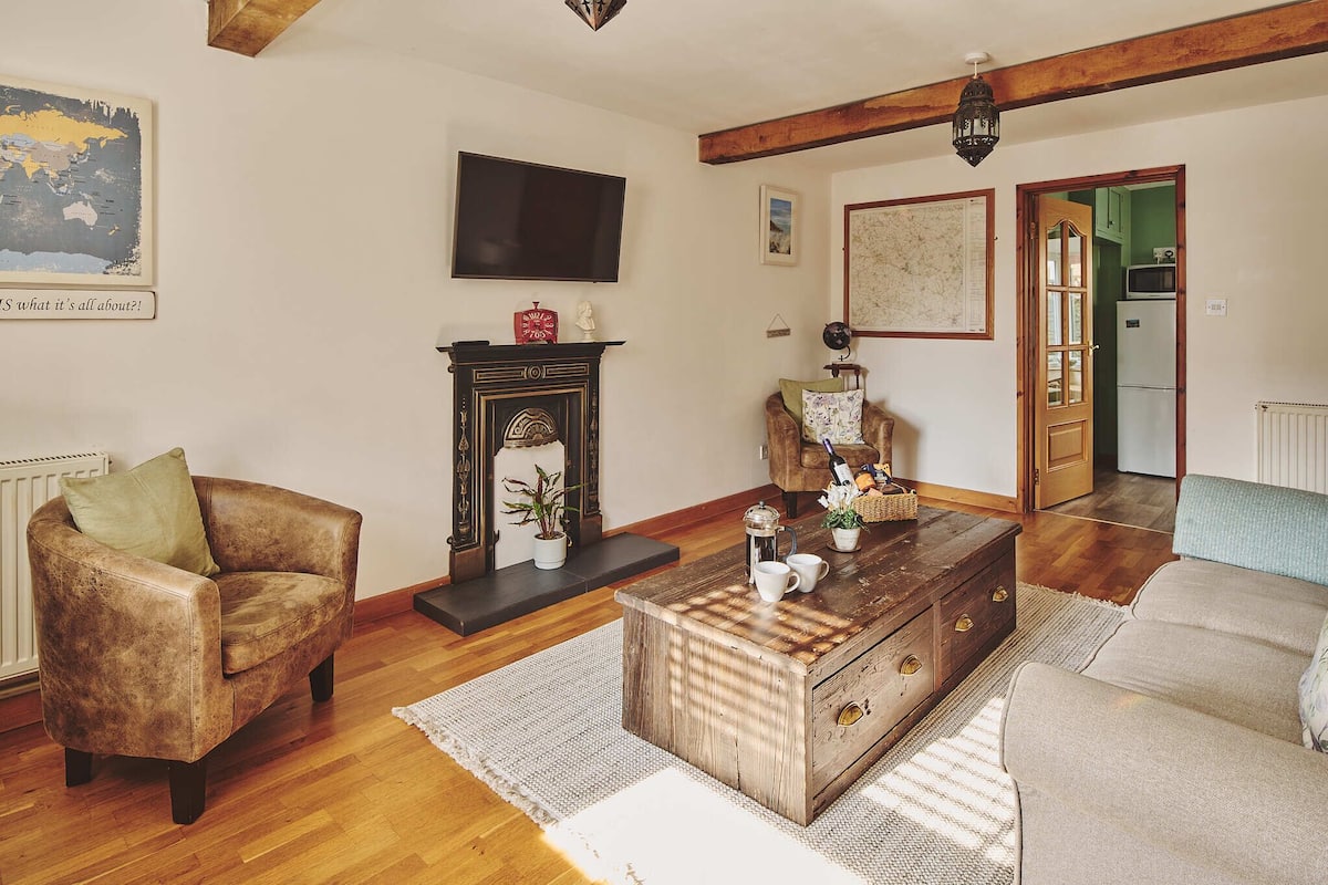 A living room with a leather armchair, a wooden coffee table, and a sofa.