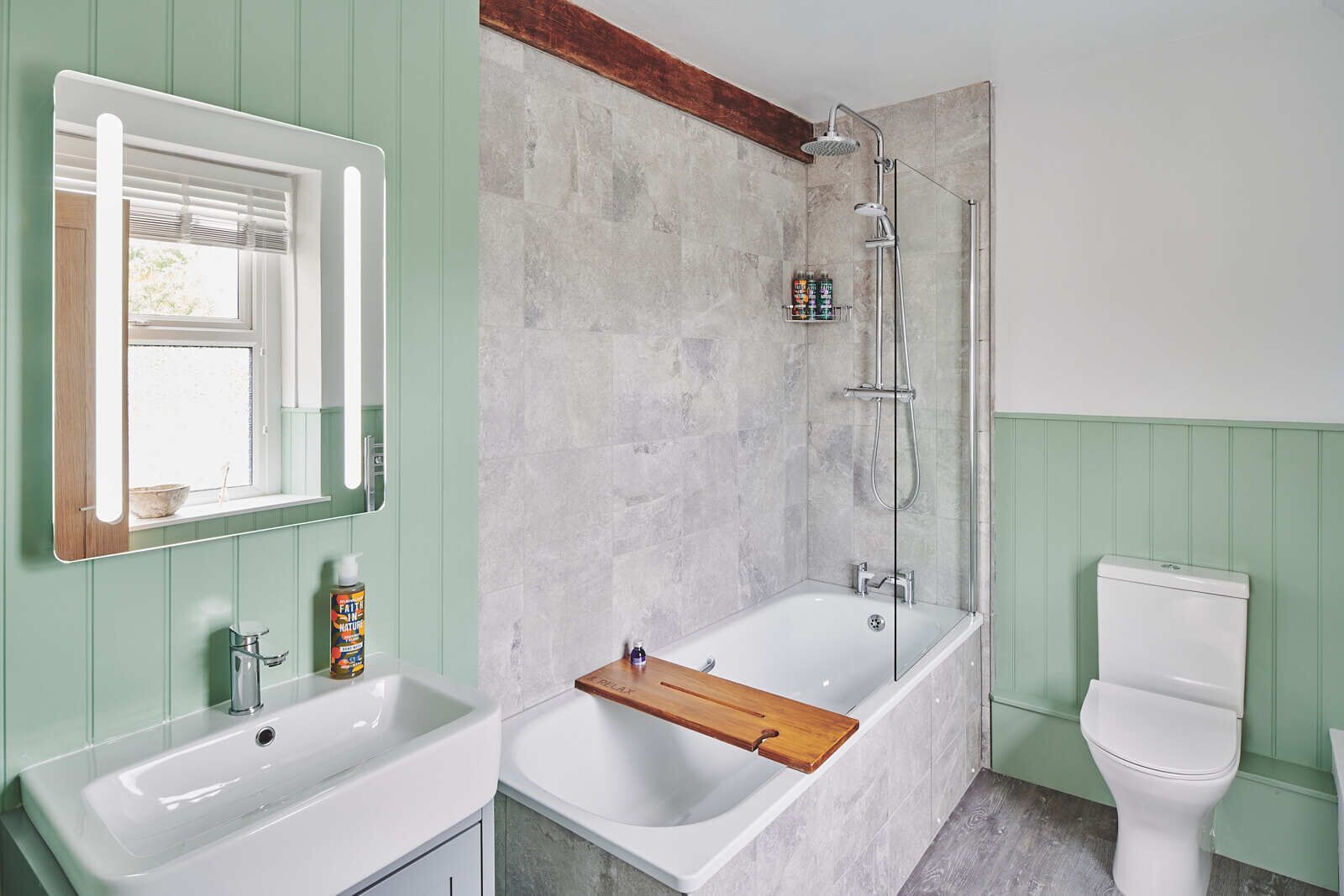 Ein Badezimmer mit einer Badewanne, einer Dusche, einer Toilette und einem Waschbecken mit Spiegel.