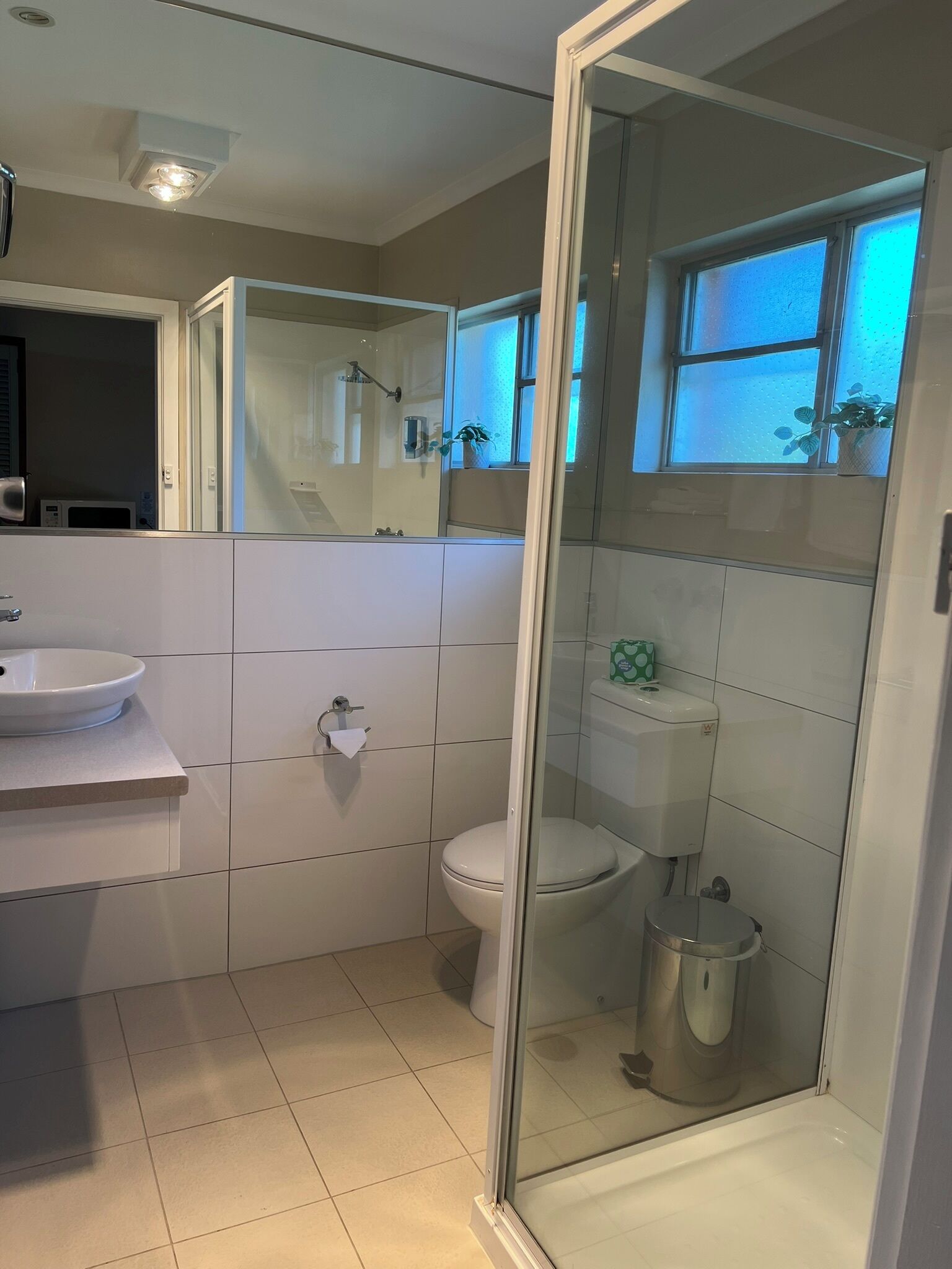 Ein modernes Badezimmer mit einer Duschkabine, einer Toilette und einem Waschbecken.