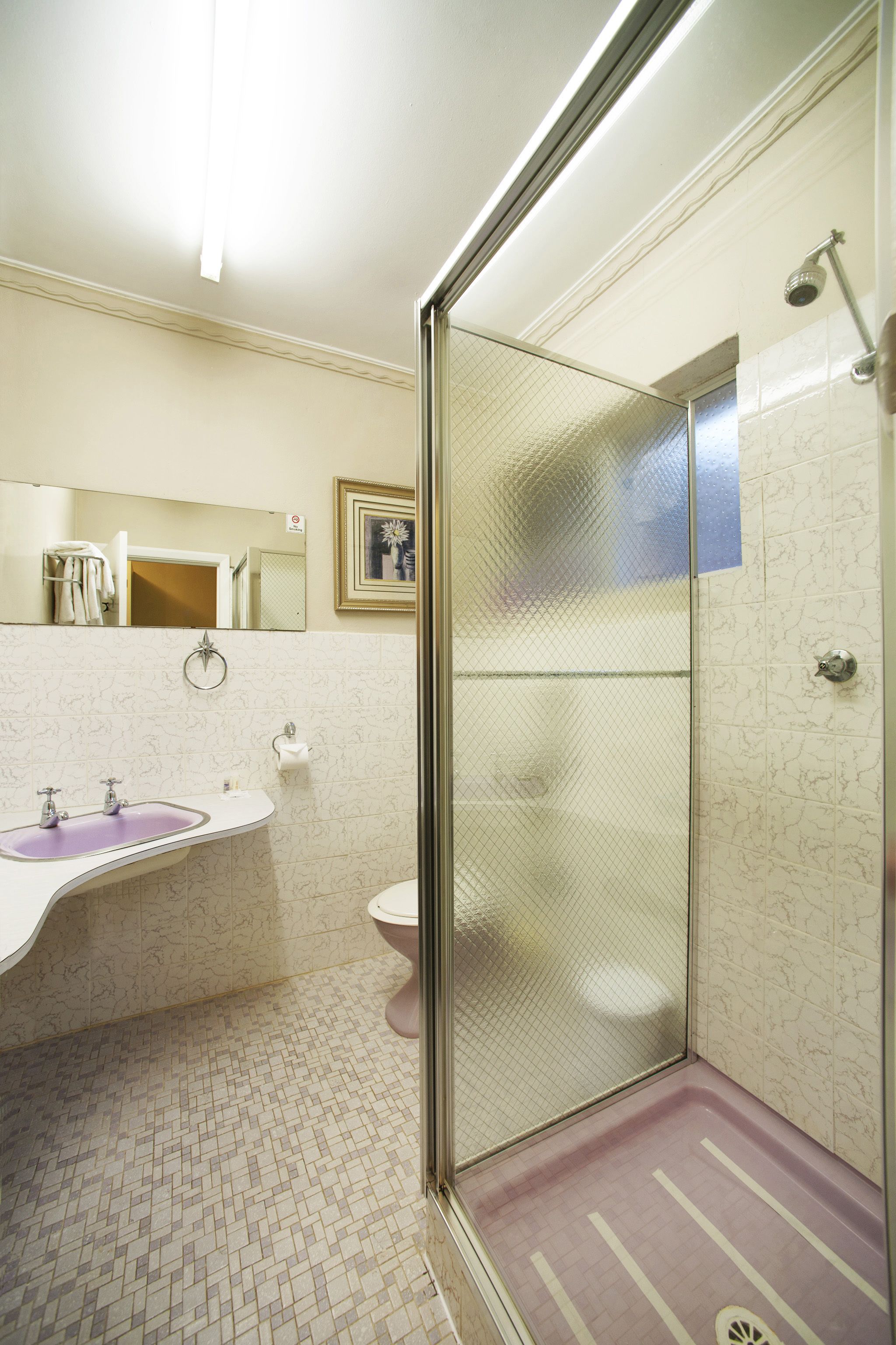 A bathroom with a shower, toilet, and sink.