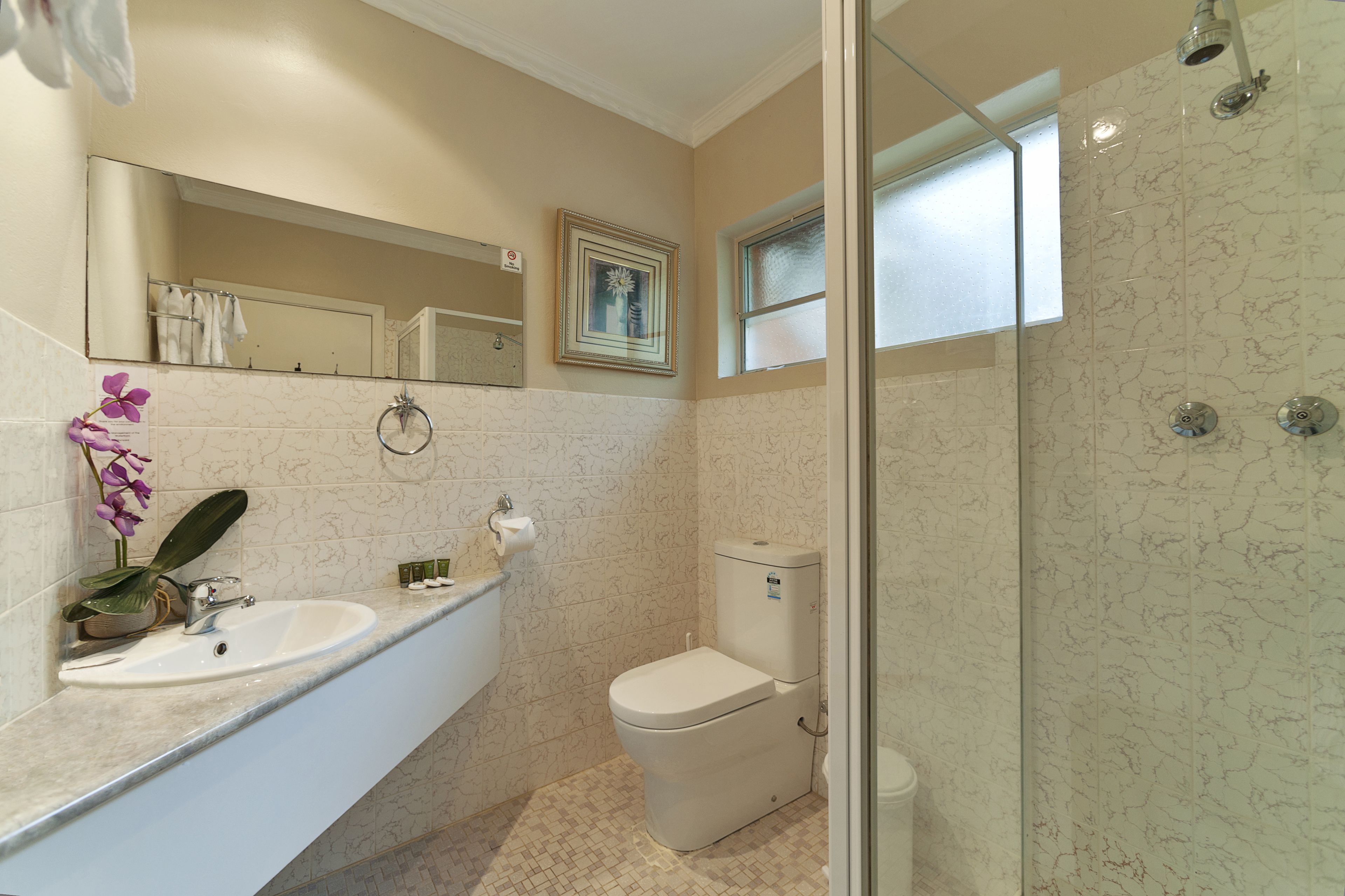A bathroom with a sink, toilet, and shower.
