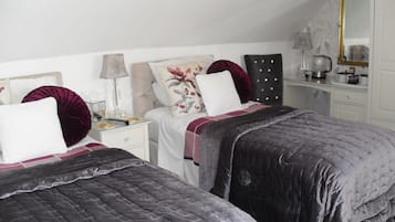 A bedroom with two beds, a nightstand, a dresser, and a mirror.