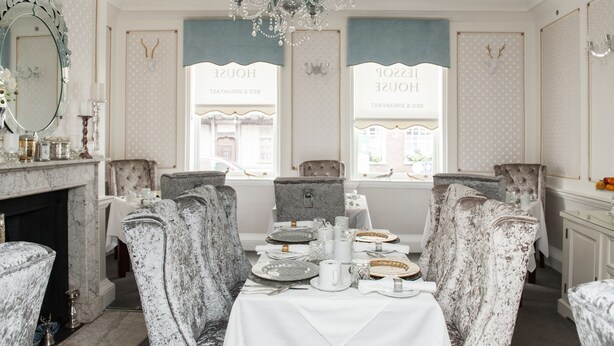 A dining room with a white table set for four, surrounded by upholstered chairs. - Jessop House (Tewkesbury)
