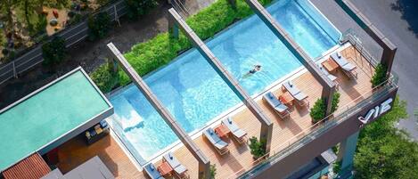 Een buitenzwembad, parasols voor strand/zwembad