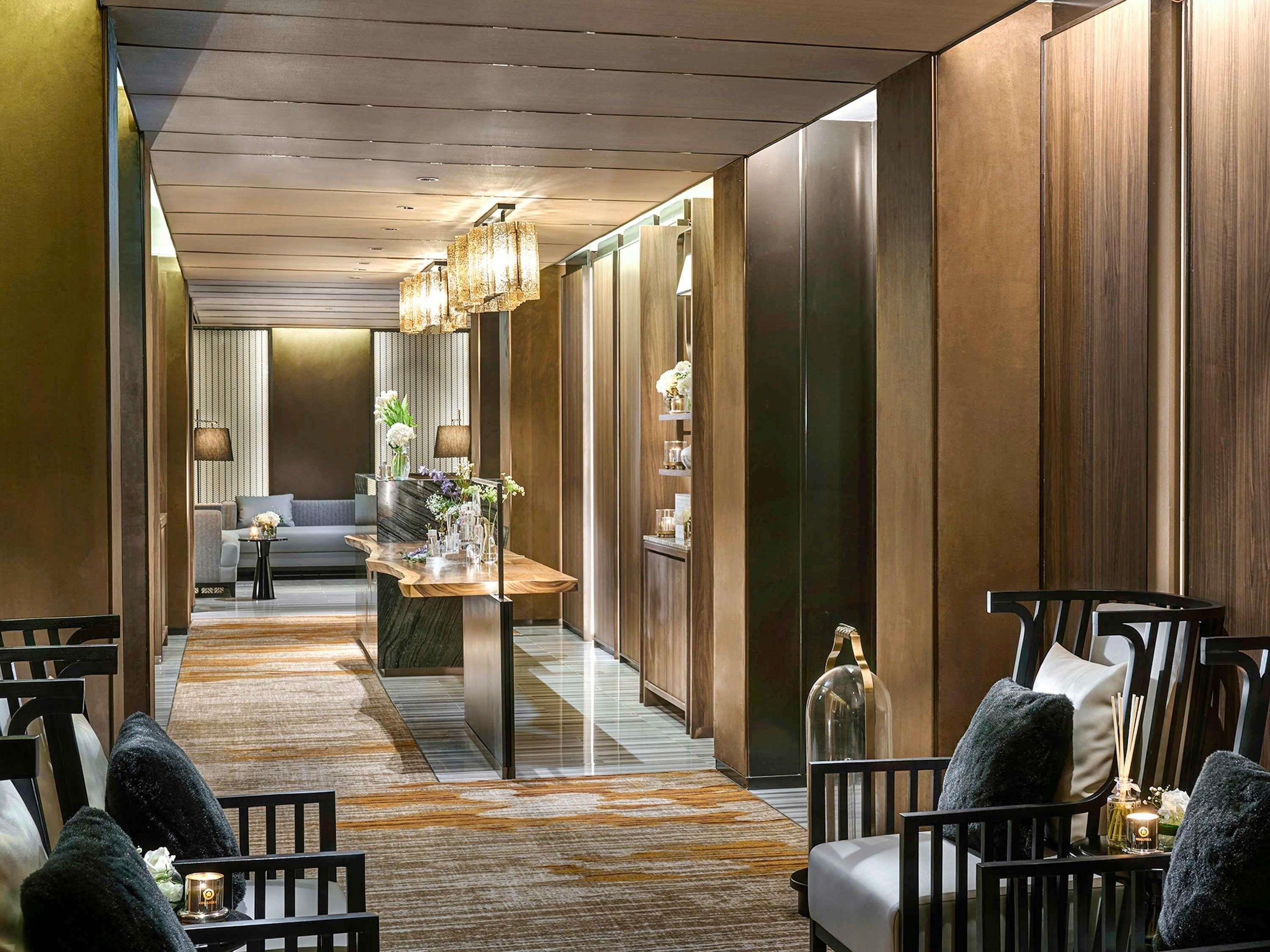 A hotel lobby with a reception desk, seating area, and a sofa in the background.
