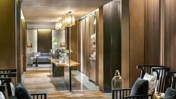 A hotel lobby with a reception desk, seating area, and a sofa in the background.